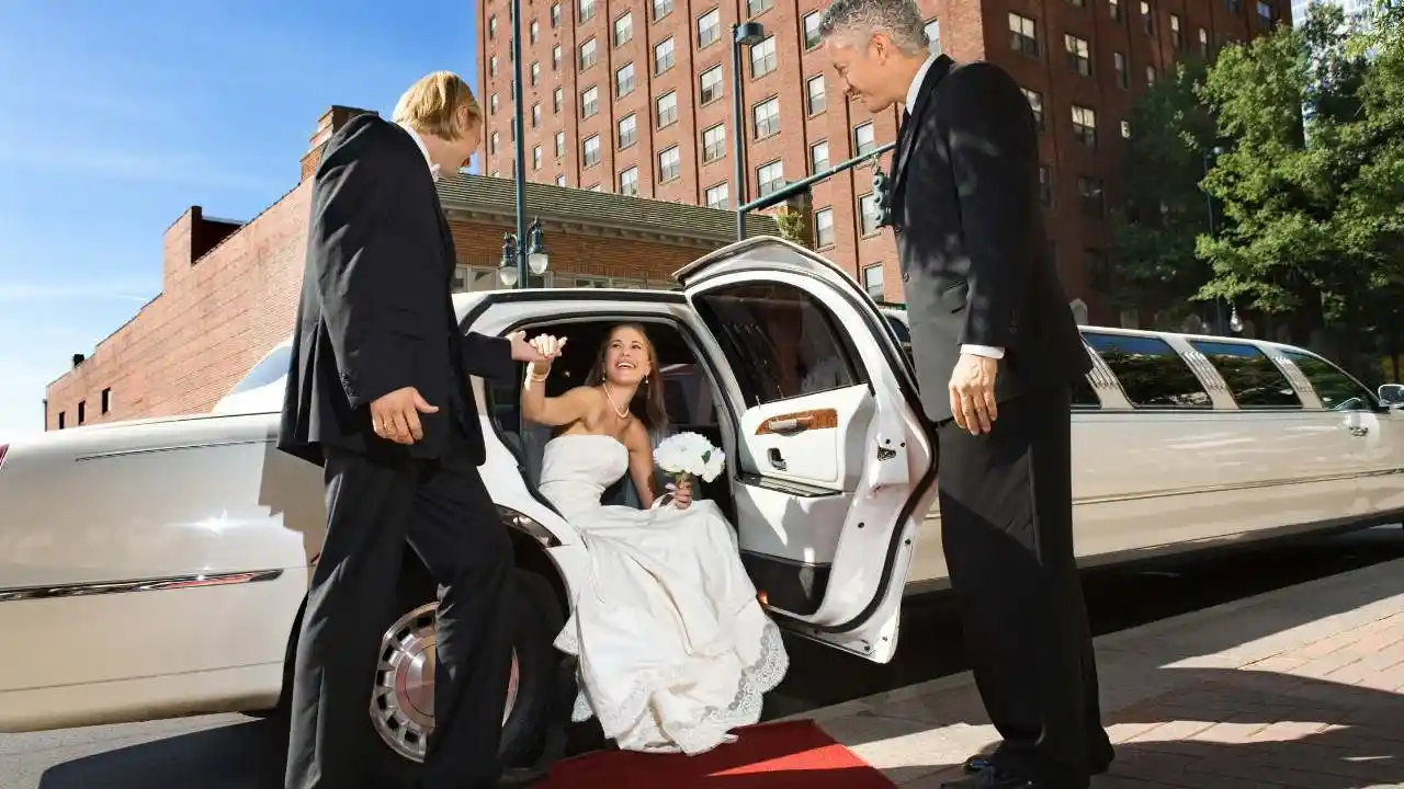The bride gets out of a long limousine